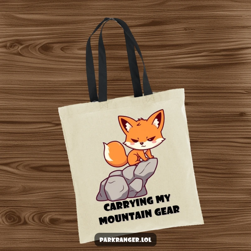 Funny tote bag featuring a small, determined fox character scaling a stylized rock with a cheerful grin.